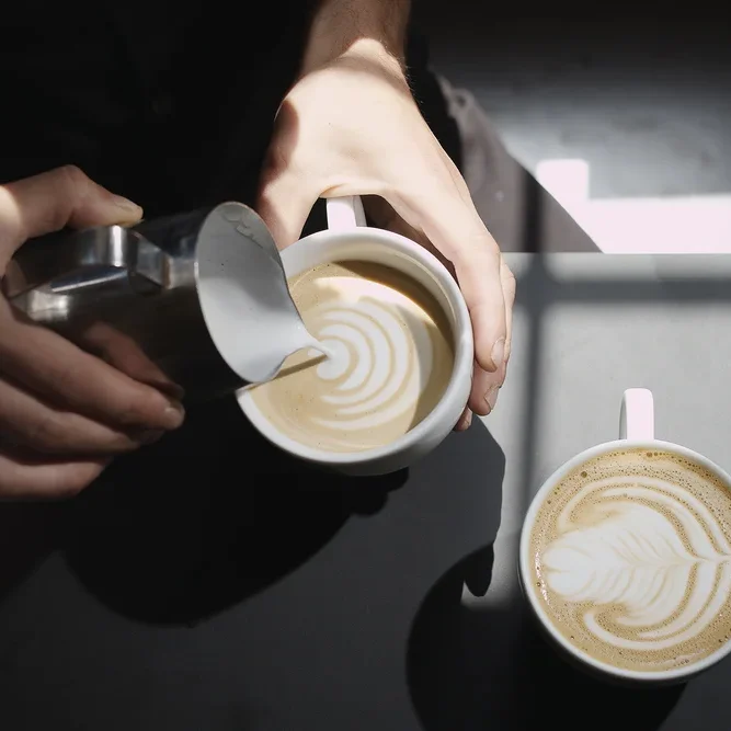 Une personne préparant un café en Latte Art
