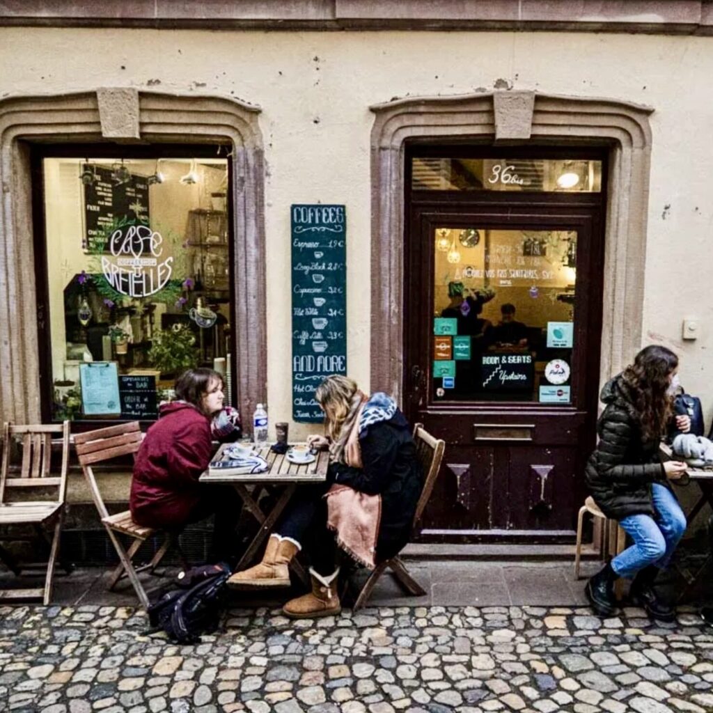 Terrasse du Café Bretelles à Strasbourg, où les clients profitent d’un café dans une ambiance conviviale