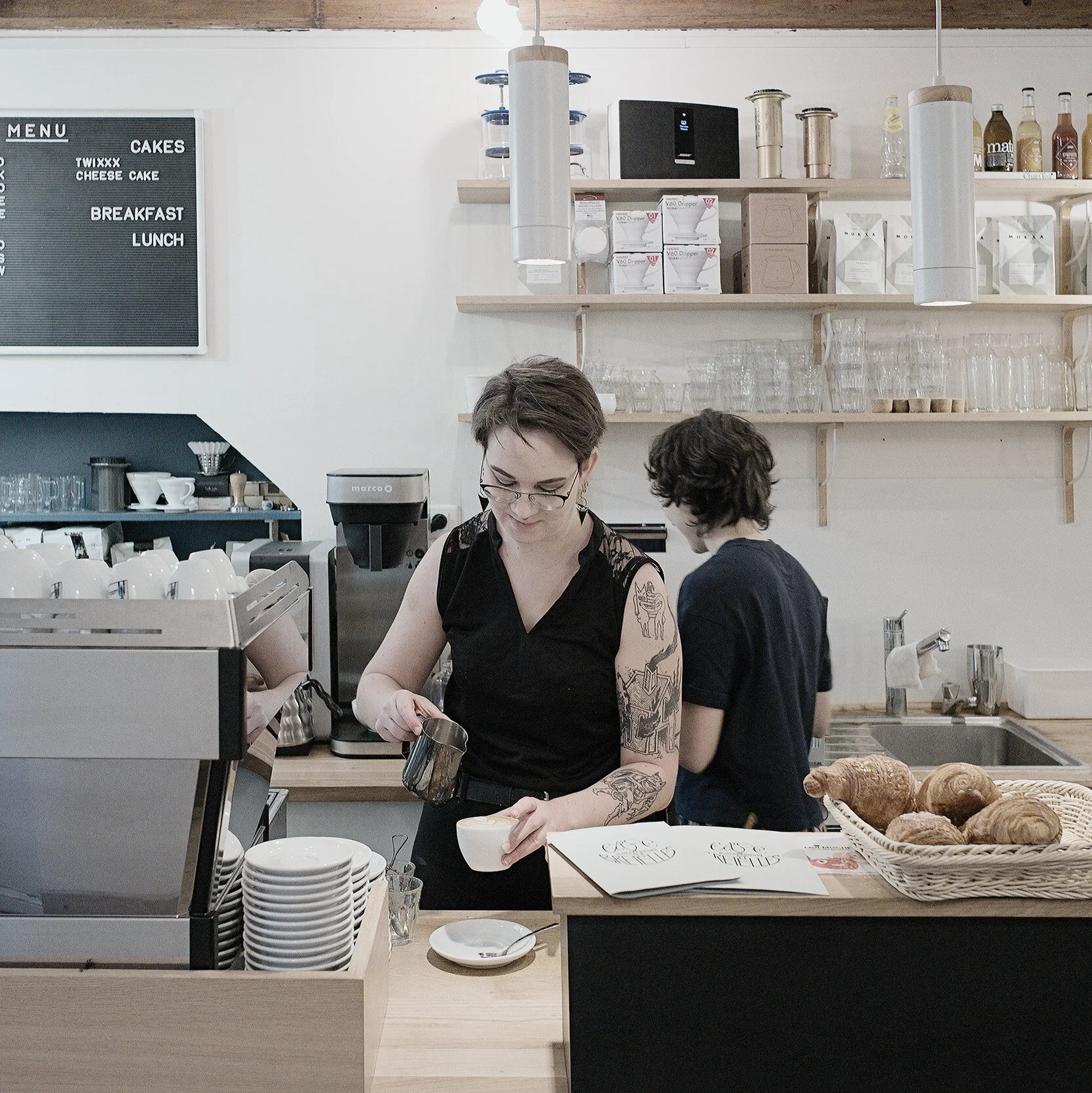 Comptoir du Café Bretelles de la Petite France à Strasbourg où une barista prépare un bon café avec soin et savoir faire.